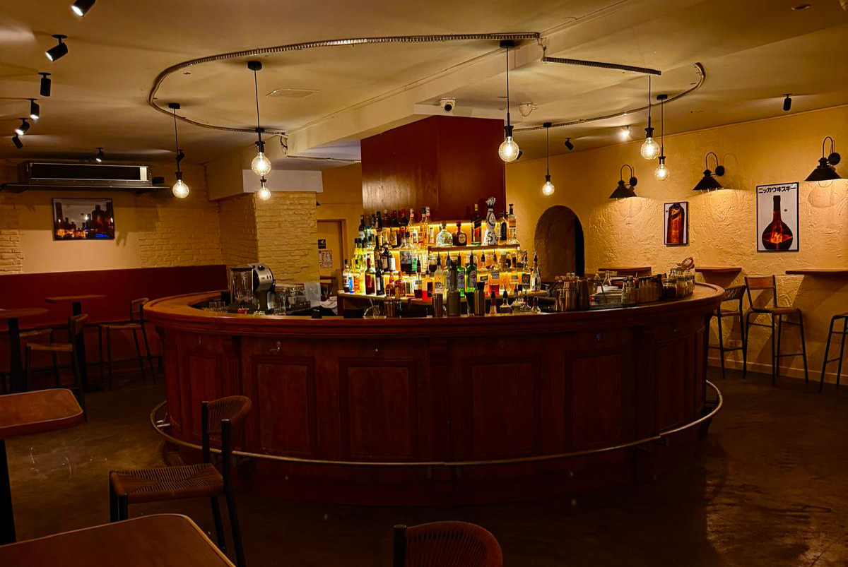 Le comptoir arrondi en bois et la salle du bar avant le service